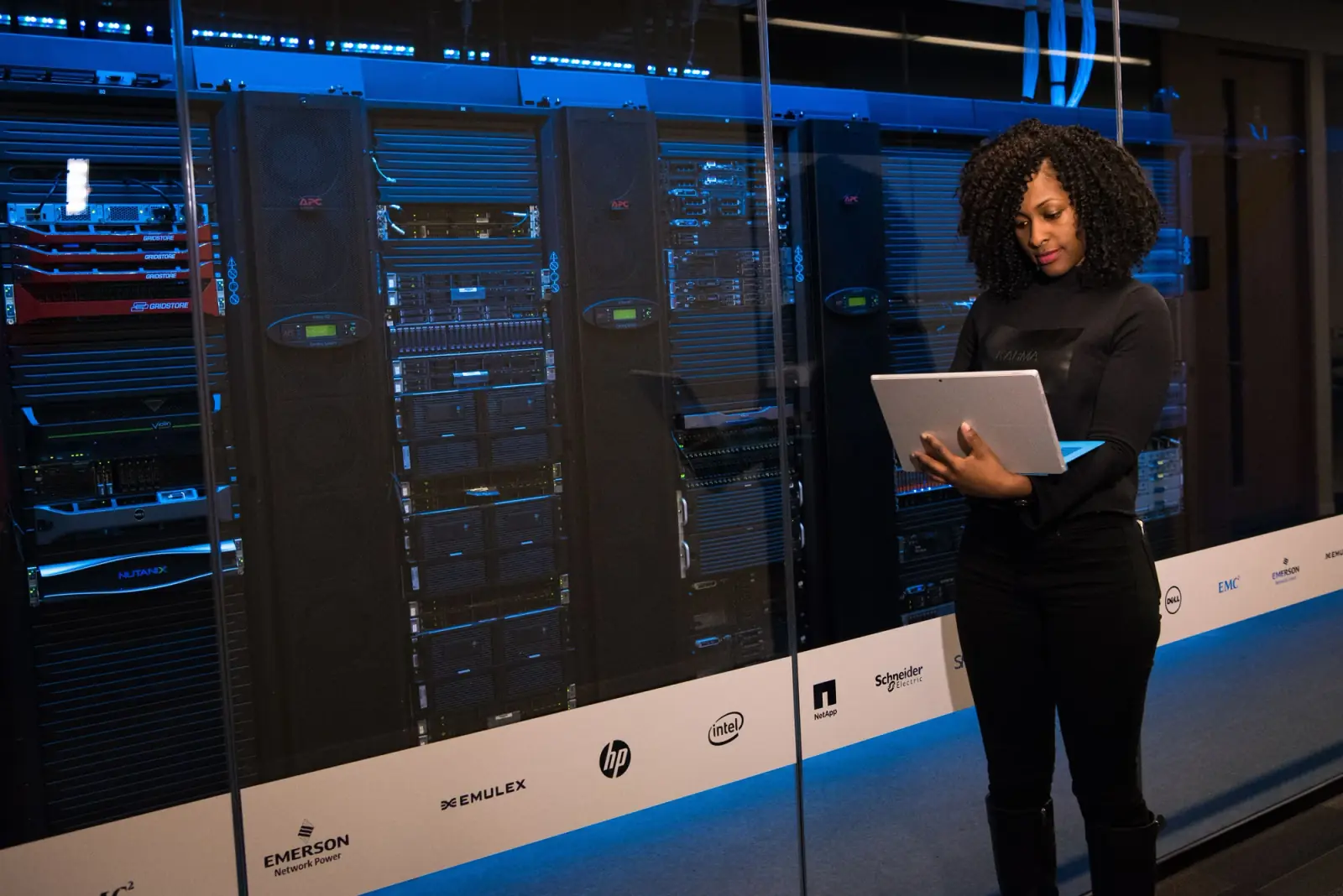 An engineer checking cabling at the back of server racks