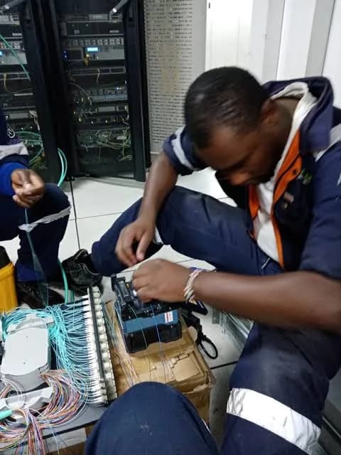 Technician working with network cabling in a data hall