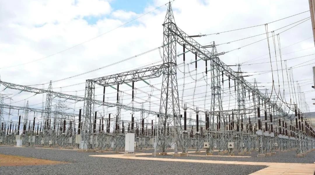 Yard of a high-voltage substation with busbars, insulators and gantries under a wide sky