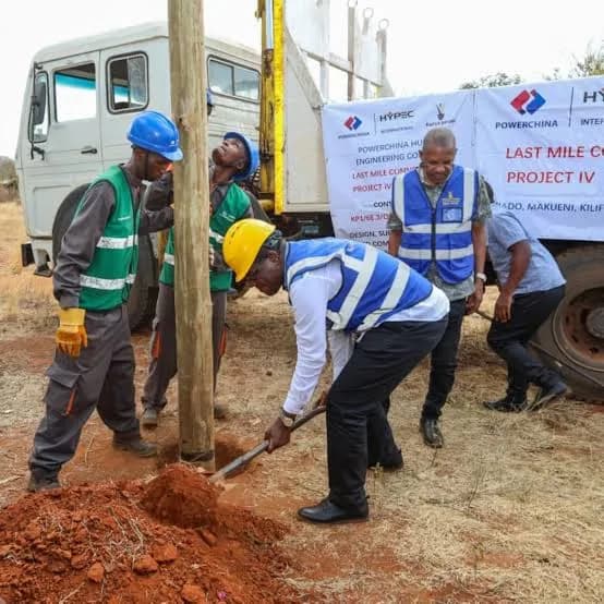 Technicians erecting a fibre distribution pole in rural Makueni