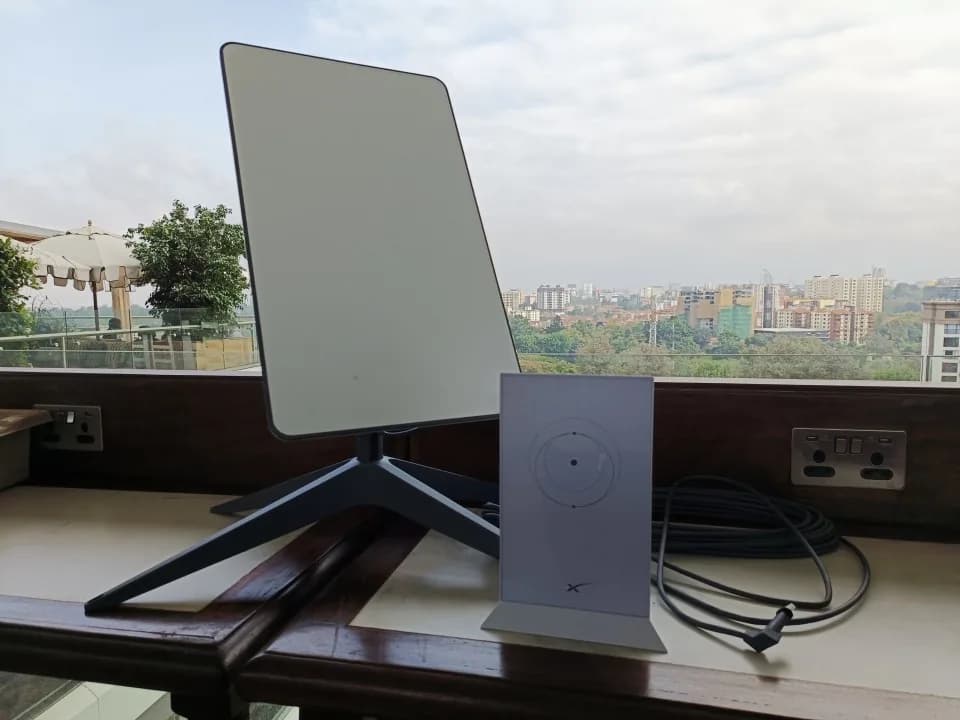 Starlink dish and Wi-Fi router installed indoors, city skyline outside the window